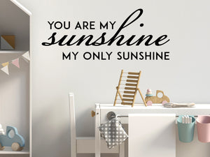 Wall decal for kids in a black color that says ‘You Are My Sunshine’ in a script font on a kid’s room wall. 