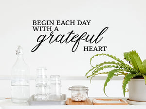 Wall decals for kitchen that say ‘begin each day with a grateful heart’ on a kitchen wall.
