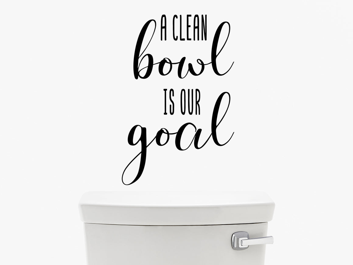 Wall decal for the bathroom that says ‘A clean bowl is our goal’ on a bathroom wall.