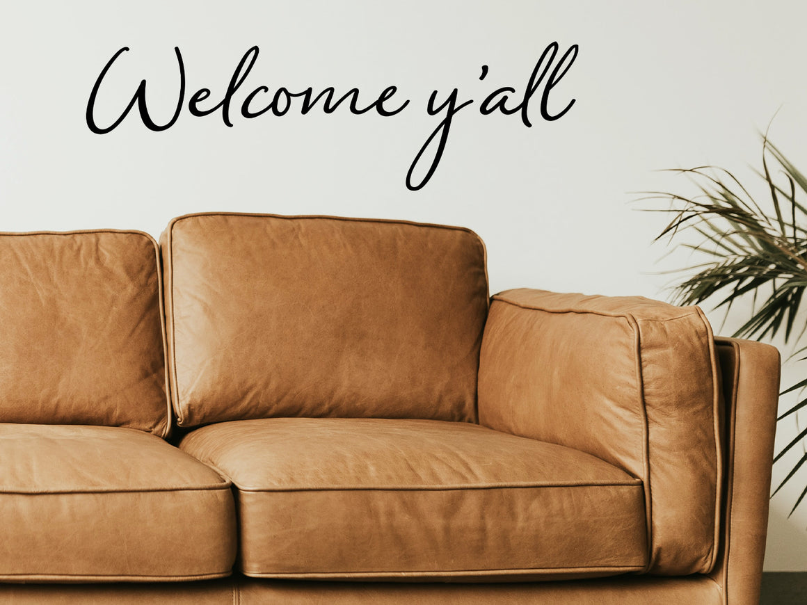 Living room wall decals that say ‘Welcome Y'all’ in a script font on a living room wall. 