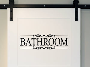 Wall decals for bathroom that say ‘Bathroom’ with a ribbon design on a bathroom wall.