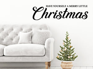 Living room wall decals that say ‘Have Yourself A Merry Little Christmas’ in a cursive font on a living room wall. 