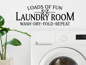 Decorative wall decal that says ‘Laundry Room Loads Of Fun Wash Dry Fold Repeat’ on a kitchen wall.