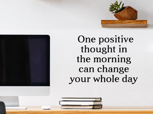 Wall decal for the office that says ‘One Small Positive Thought In The Morning’ in a print font on an office wall.