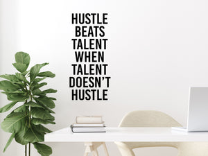 Wall decal for the office that says ‘Hustle Beats Talent When Talent Doesn’t Hustle’ in a bold font on an office wall.