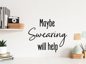 Wall decal for the office that says ‘Maybe Swearing Will Help’ in a script font on an office wall.