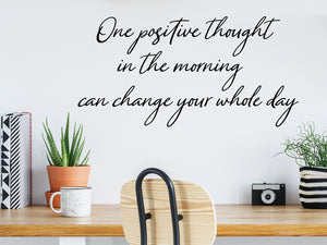 Wall decal for the office that says ‘One Small Positive Thought In The Morning’ in a cursive font on an office wall.