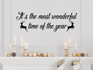 Living room wall decals that say ‘It's The Most Wonderful Time Of The Year’ in a cursive font on a living room wall. 