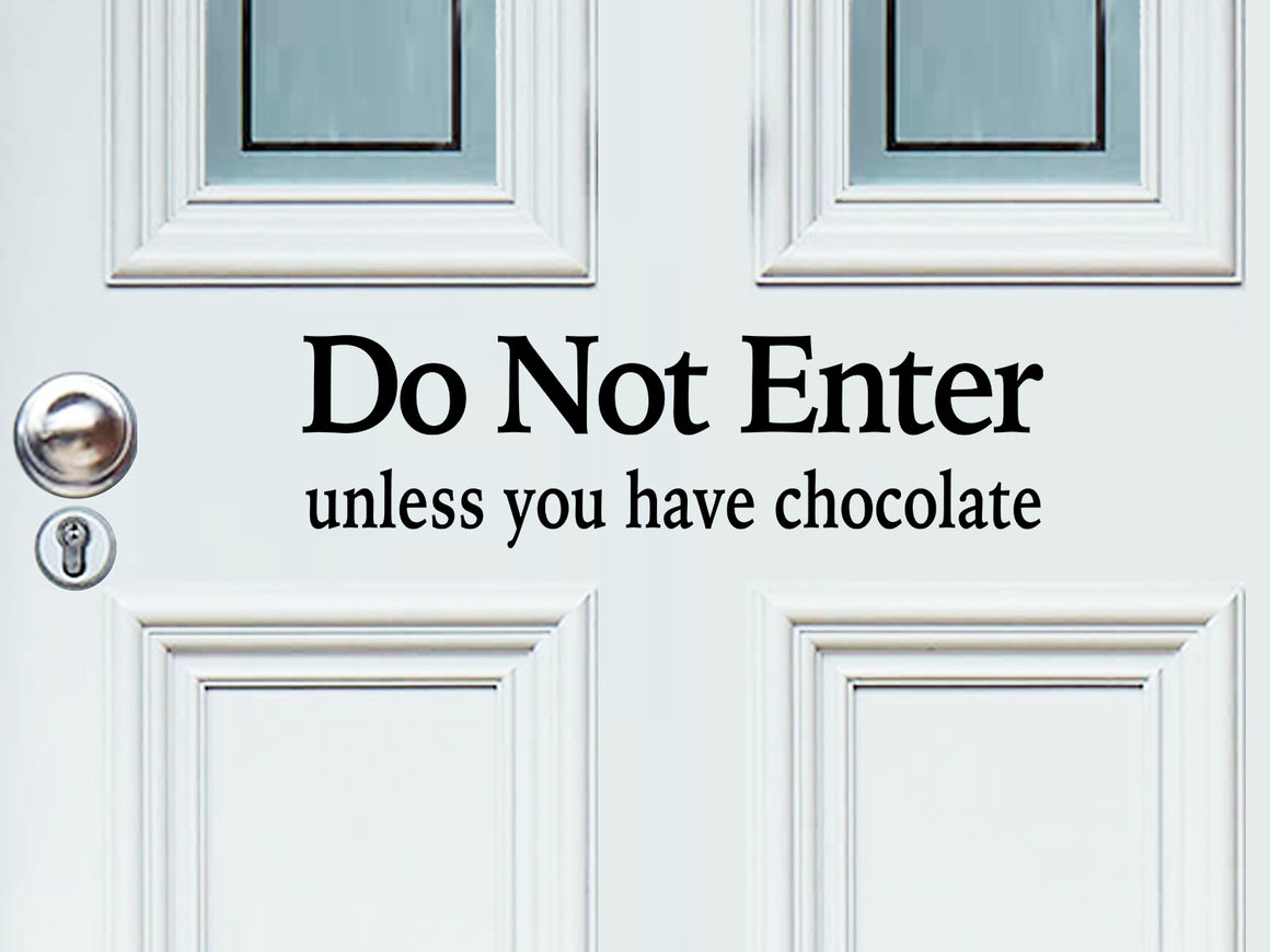 Front door decal that says, ‘Do Not Enter Unless You Have Chocolate’ on a front porch door. 