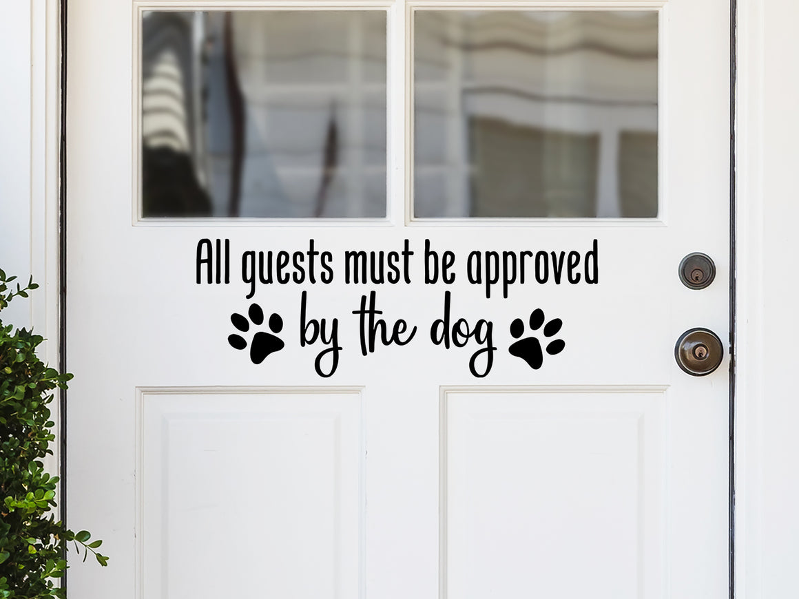 Front door decal that says, ‘All Guests Must Be Approved By The Dog’ in a print font on a front porch door.
