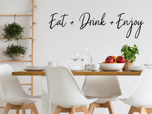 Wall decals for kitchen that say ‘Eat Drink Enjoy’ in a script font on a kitchen wall.