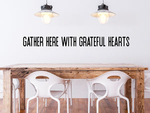 Wall decals for kitchen that say ‘Gather Here With Grateful Hearts’ in a print font on a kitchen wall.