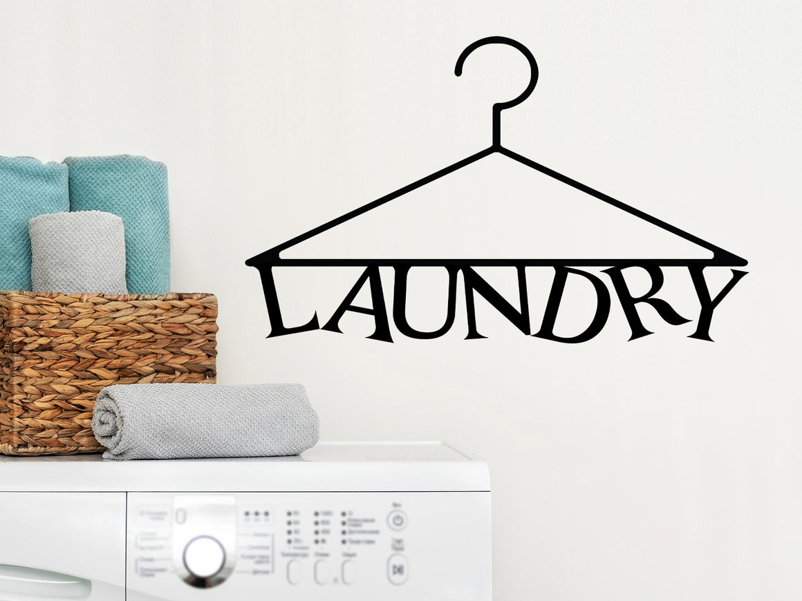 Laundry room wall decal that says ‘Laundry (Clothes Hanger)’ in a print font on a laundry room wall.