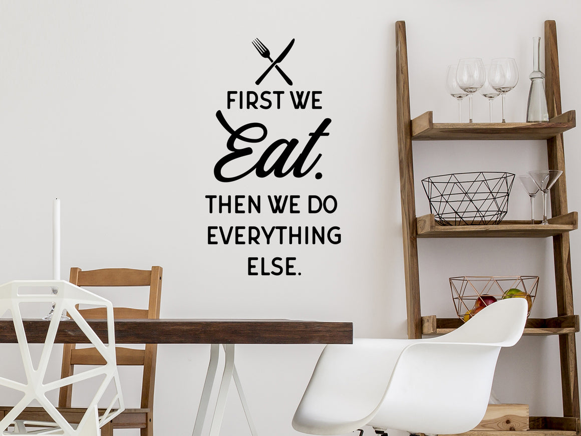 Wall decals for kitchen that say ‘First we eat. Then we do everything else.’ on a kitchen wall.