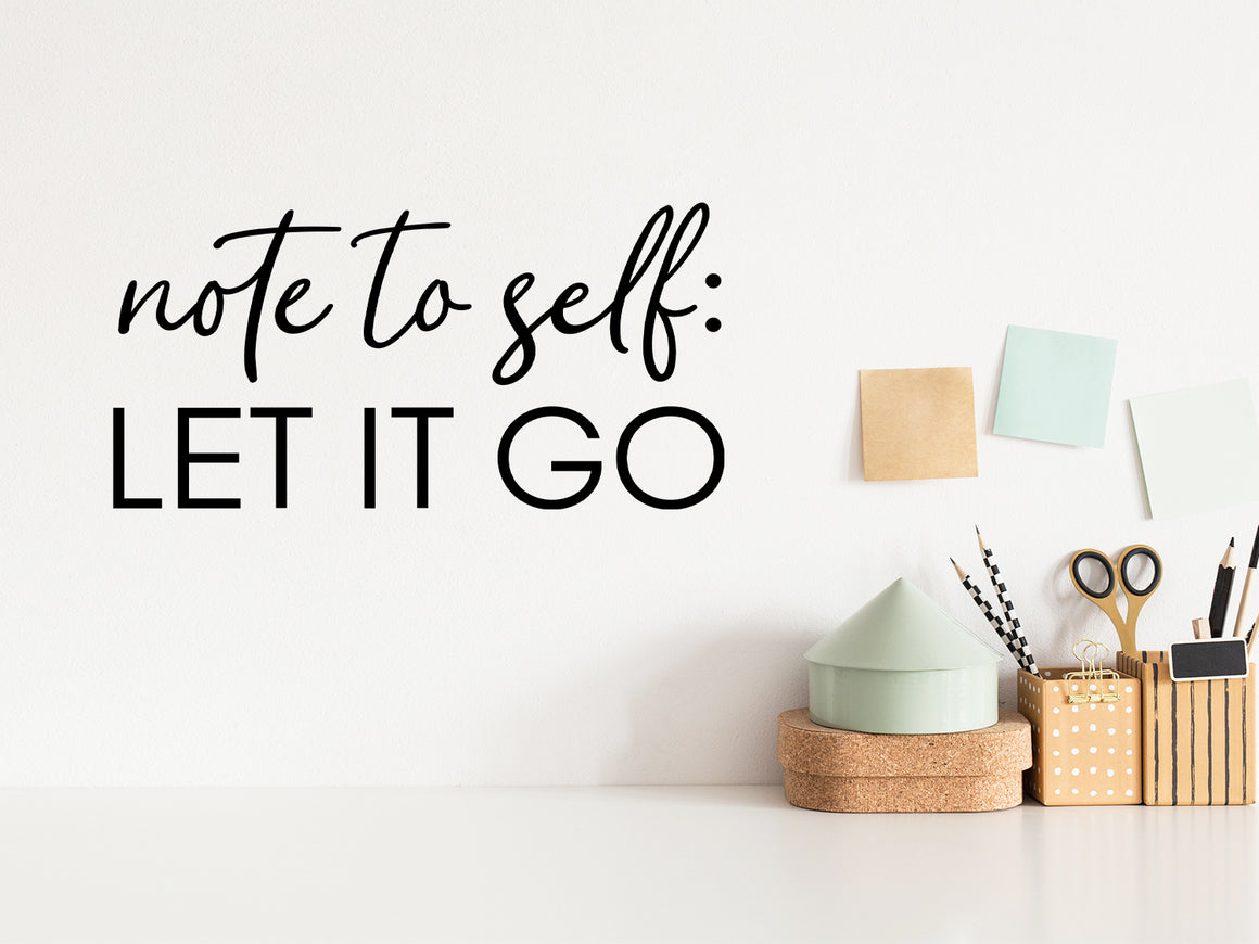 Wall decal for the office that says ‘Note To Self Let It Go' in a script font on an office wall.