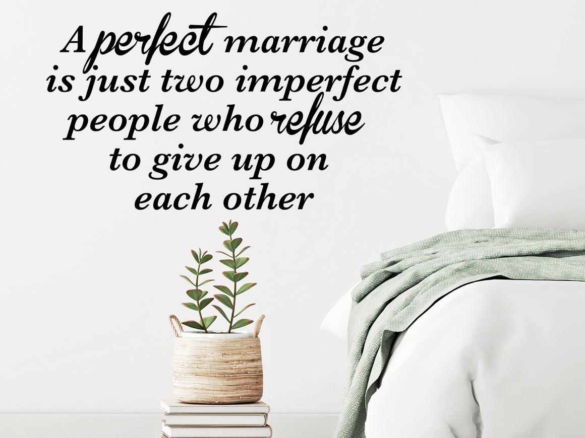 Wall decal for bedroom that says ‘a perfect marriage is just two imperfect people who refuse to give up on each other’ on a bedroom wall.