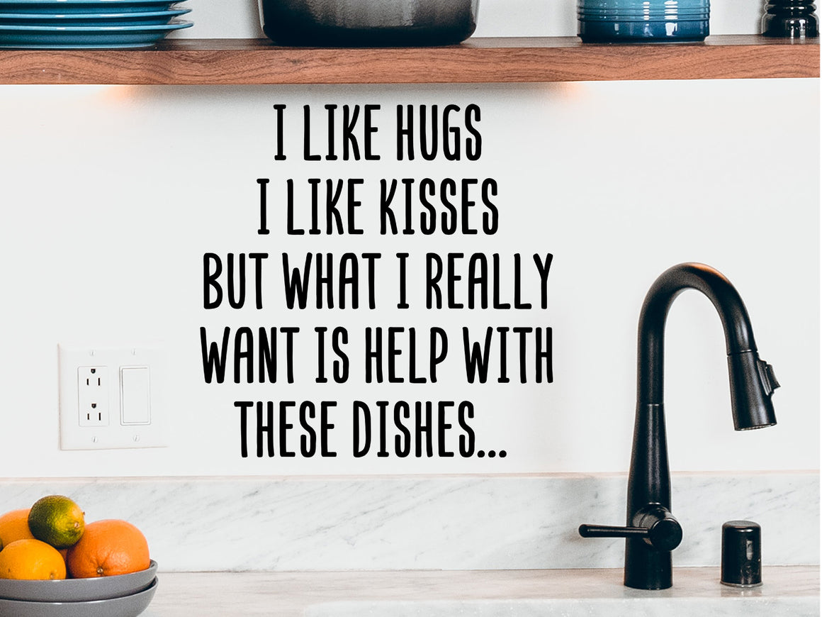 Decorative wall decal that says ‘I Like Hugs I Like Kisses But What I Really Want Is Help With These Dishes’ on a kitchen wall.