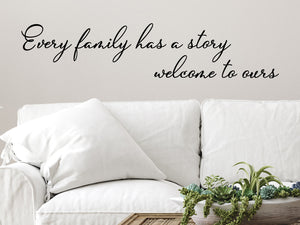 Living room wall decals that say ‘Every Family Has A Story Welcome To Ours’ in a cursive font on a living room wall.
