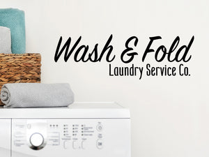 Laundry room wall decal that says ‘Wash And Fold Laundry Service Co.’ on a laundry room wall.