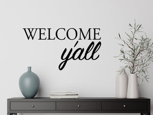 Living room wall decals that say ‘Welcome Y'all’ in a bold font on a living room wall. 