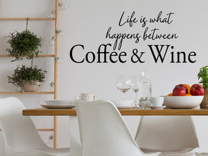 Wall decals for kitchen that say ‘Life Is What Happens Between Coffee And Wine’ in a cursive font on a kitchen wall.