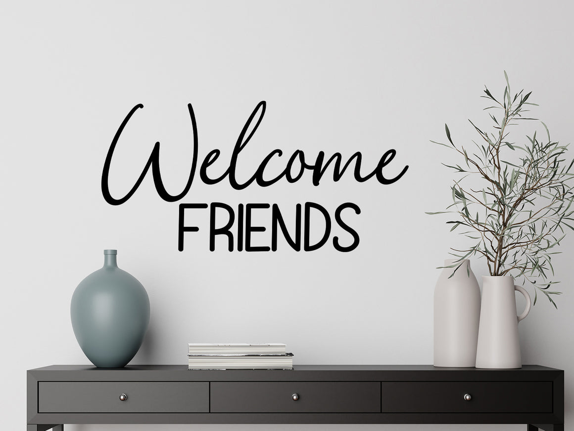 Living room wall decals that say ‘Welcome Friends’ in a script font on a living room wall. 