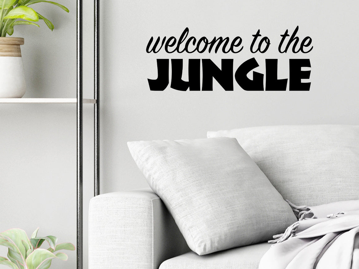 Living room wall decals that say ‘Welcome To The Jungle’ in a bold font on a living room wall. 