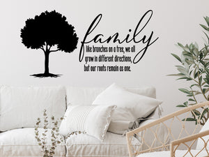 Living room wall decals that say ‘Family Like Branches On A Tree’ in a script font on a living room wall. 