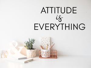 Wall decal for the office that says ‘Attitude Is Everything’ in a print font on an office wall.