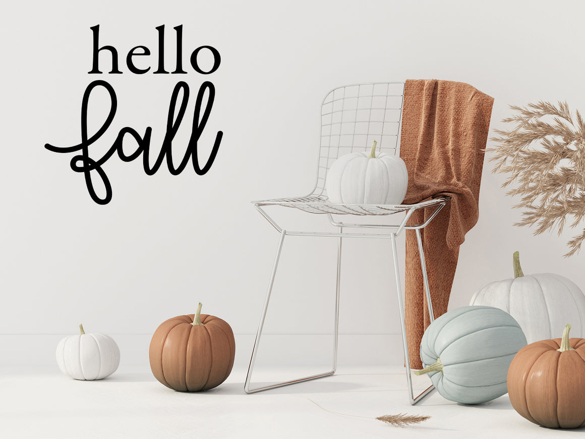 Living room wall decals that say ‘Hello Fall’ in a script font on a living room wall. 