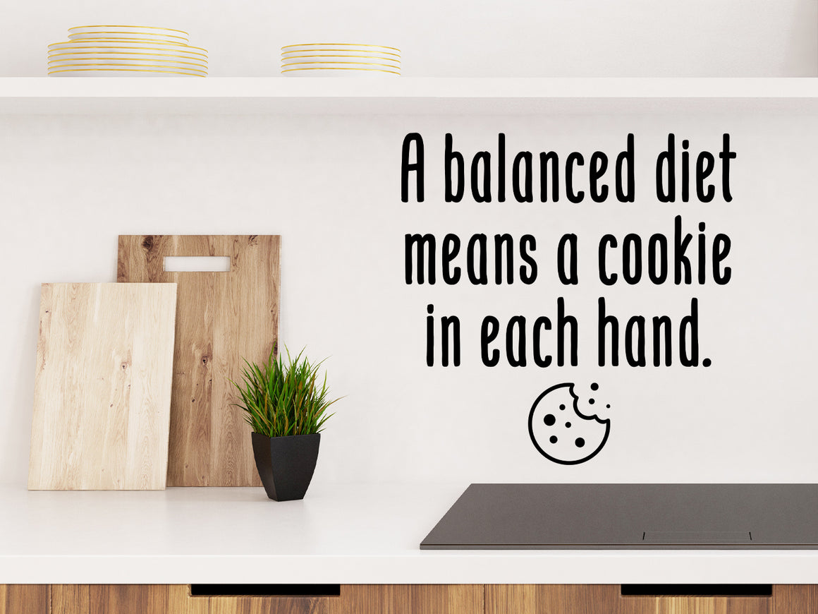 Decorative wall decal that says ‘A Balanced Diet Means A Cookie In Each Hand’ on a kitchen wall.