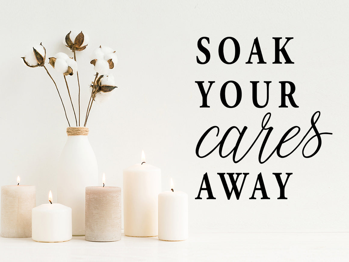Wall decals for bathroom that say ‘soak your cares away’ on a bathroom wall.