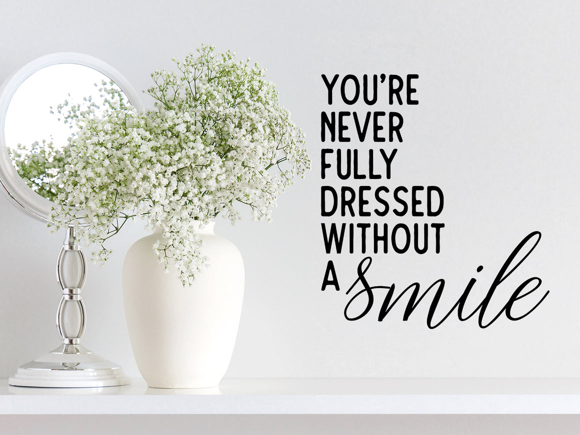 Wall decals for bathroom that say ‘you're never fully dressed without a smile’ on a bathroom wall.