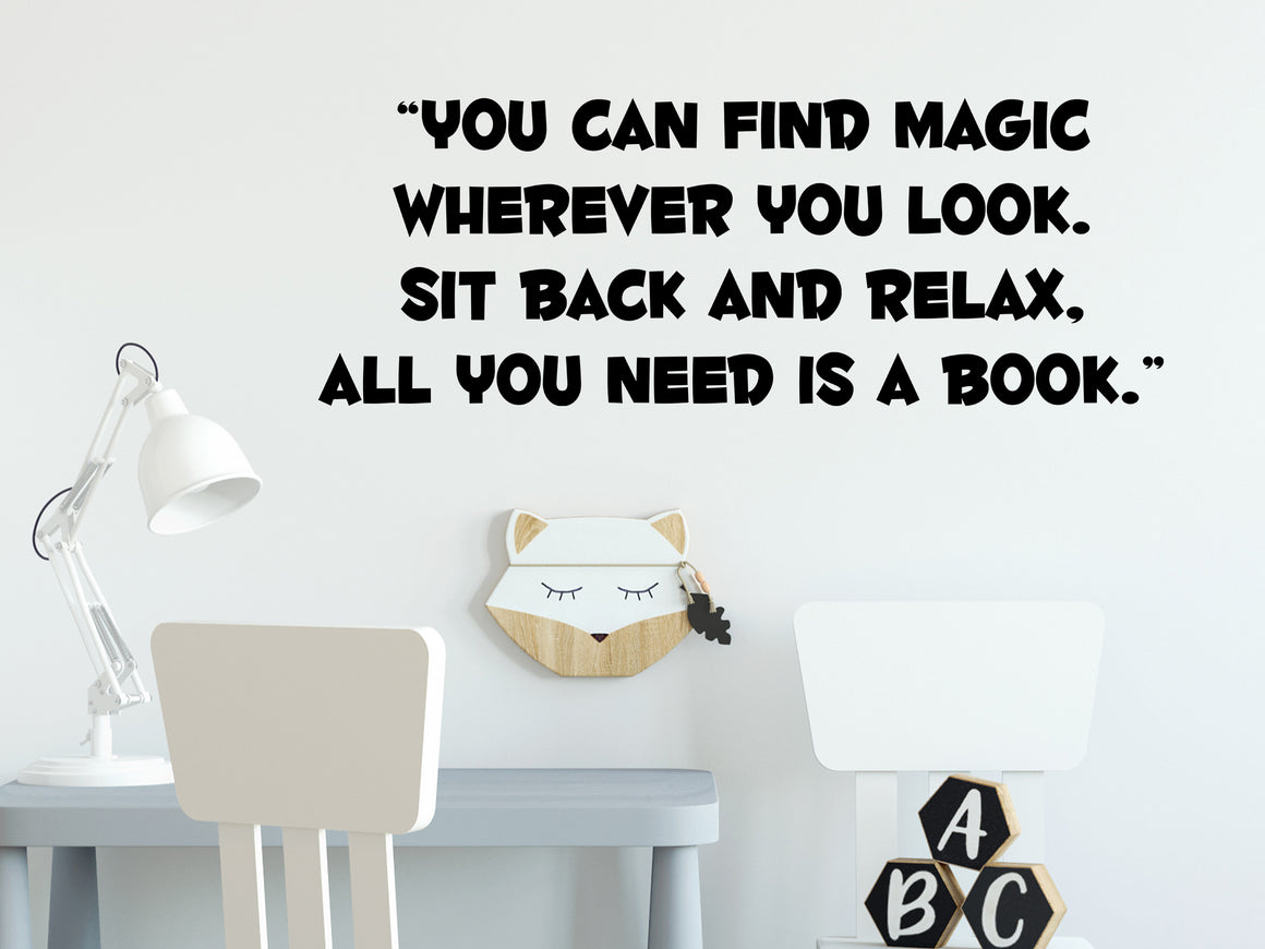 Wall decal for kids in a black color that says ‘You Can Find Magic Wherever You Look’ in a bold font on a kid’s room wall. 