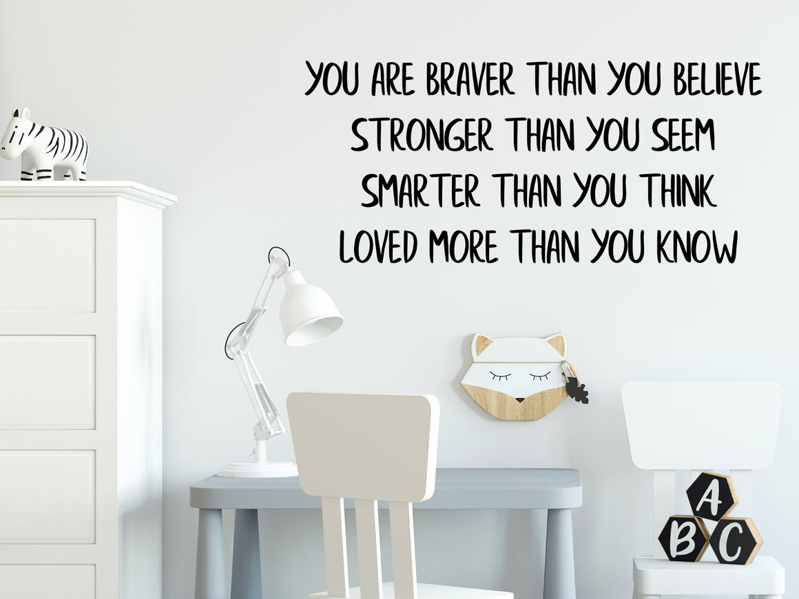 Wall decal for kids in a black color that says ‘You Are Braver Than You Believe’ in a print font on a kid’s room wall. 
