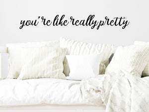 Wall decal for kids in a black color that says ‘You're Like Really Pretty’ in a cursive font on a kid’s room wall. 