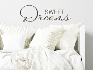 Wall decal for kids in a brown color that says ‘Sweet Dreams’ in a script font on a kid’s room wall. 