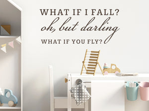 Wall decal for kids in a brown color that says ‘What If I Fall, Oh But My Darling, What If You Fly?’ in a script font on a kid’s room wall. 