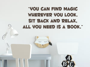 Wall decal for kids in a brown color that says ‘You Can Find Magic Wherever You Look’ in a bold font on a kid’s room wall. 