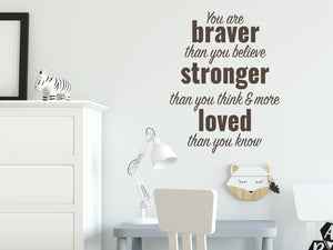 Wall decal for kids in a brown color that says ‘You Are Braver Than You Believe’ in a dual font on a kid’s room wall. 