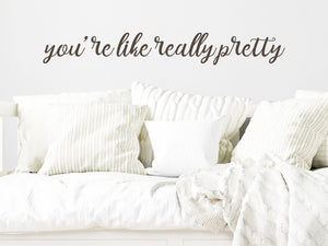 Wall decal for kids in a brown color that says ‘You're Like Really Pretty’ in a cursive font on a kid’s room wall. 