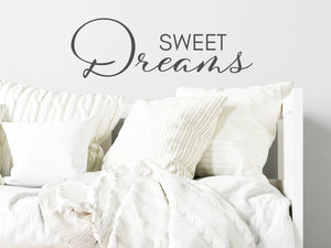 Wall decal for kids in a grey color that says ‘Sweet Dreams’ in a script font on a kid’s room wall. 