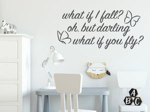 Wall decal for kids in a grey color that says ‘What If I Fall, Oh But My Darling, What If You Fly?’ in a cursive font on a kid’s room wall. 