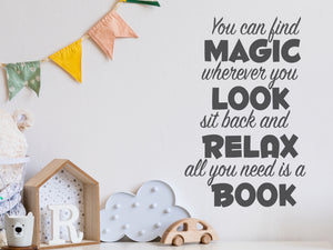 Wall decal for kids in a grey color that says ‘You Can Find Magic Wherever You Look’ in a dual font on a kid’s room wall. 