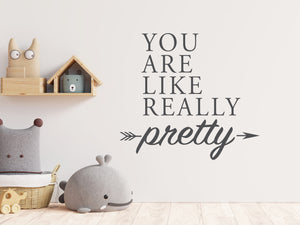 Wall decal for kids in a grey color that says ‘You Are Like Really Pretty’ with an arrow design on a kid’s room wall. 