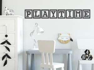 Wall decal for kids that says ‘Playtime’ in grey with blocks on a kid’s room wall. 