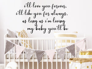 Wall decal for kids that says ‘I'll love you forever i'll like you for always as long as i'm living my baby you'll be’ on a kid’s room wall.