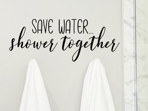 Wall decals for bathroom that say ‘save water...shower together’ on a bathroom wall.