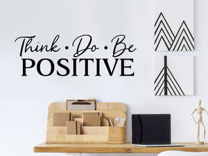 Wall decal for the office that says ‘Think Do Be Positive’ in a script font on an office wall.