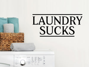 Laundry room wall decal that says ‘Laundry Sucks’ on a laundry room wall.